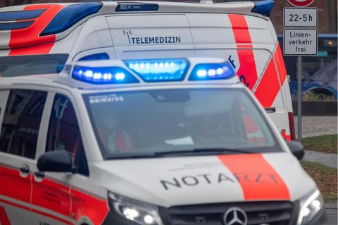 Ein weiß-roter Transporter mit schwarzem "Notarzt"-Schriftzug fährt mit Blaulicht zu einem Einsatz