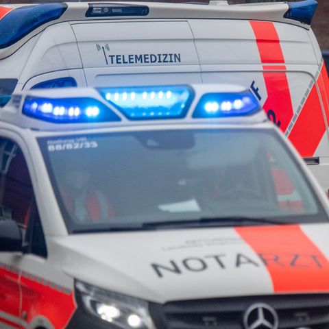 Ein weiß-roter Transporter mit schwarzem "Notarzt"-Schriftzug fährt mit Blaulicht zu einem Einsatz