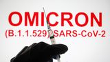 Eine Hand hält vor der Aufschrift "Omicron (B.1.1.529): SARS-CoV-2" eine Spritze hoch