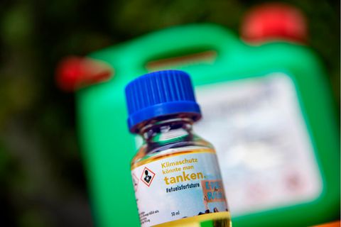 Eine Flasche steht vor einem Kanister