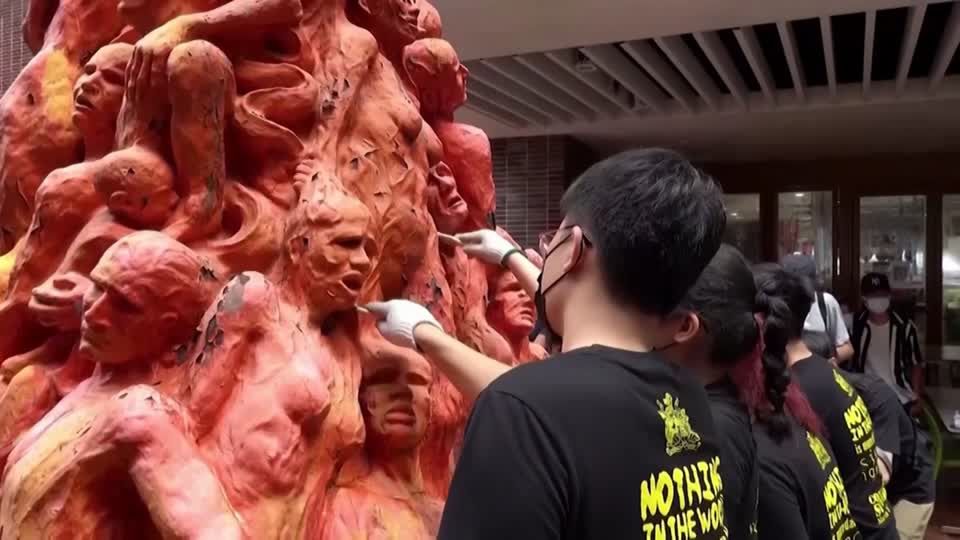 Hongkong: Skulptur zum Gedenken an Tiananmen entfernt Künstler mit Spachteln bei der Arbeit an einem Denkmal mit vielen roten Figuren