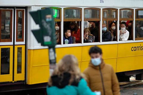 Menschen mit Mund-Nasen-Schutz fahren in einer Straßenbahn