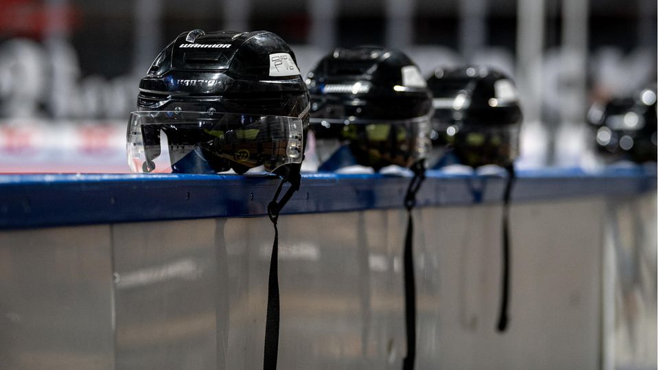 Eishockey-Helme liegen auf einer Bande