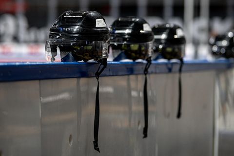 Eishockey-Helme liegen auf einer Bande