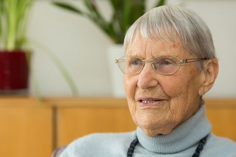Inge Jens sitzt in hellblauem Rollkragen-Pullover da und spricht