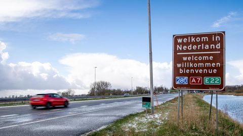 Auf einem braunen Schild an einer Autobahn steht "Welkom in Nederland", darunter "welcome", "willkommen" und "bienvenue"