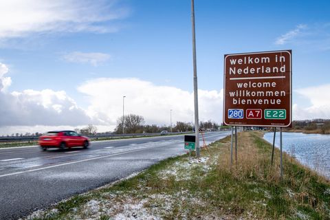 Auf einem braunen Schild an einer Autobahn steht "Welkom in Nederland", darunter "welcome", "willkommen" und "bienvenue"