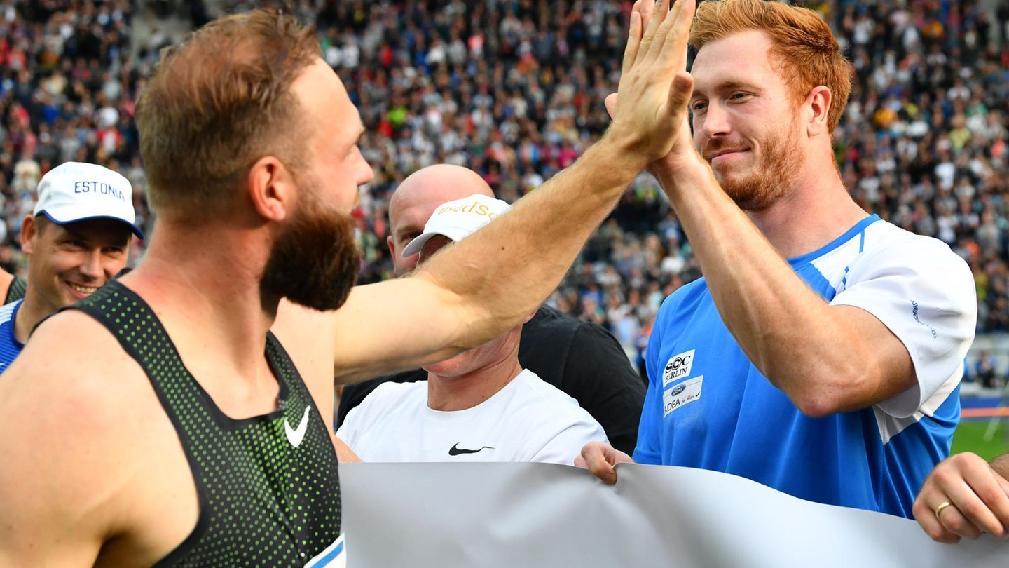 Robert und Christoph Harting klatschen sich mit der Hand ab