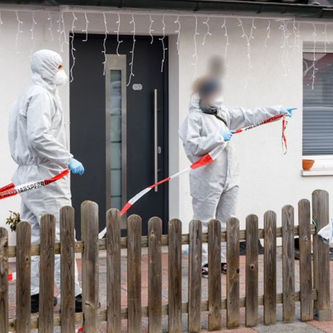 Glinde: Polizeibeamte sperren mit Flatterband den Bereich vor besagtem Haus ab.
