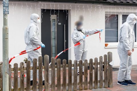 Glinde: Polizeibeamte sperren mit Flatterband den Bereich vor besagtem Haus ab.