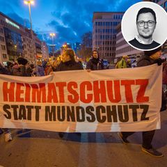 Demonstraten tragen ein Transparent mit der Aufschrit "Heimatschutz statt Mundschutz". Impfgegner, Coronaleugner und Querdenker demonstrieren Ende November in der Innenstadt von Frankfurt am Main gegen die Corona-Maßnahmen