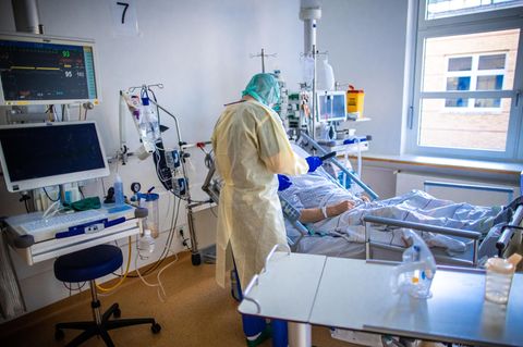 Eine Pflegekraft betreut auf einer Intensivstation einen Corona-Patienten.