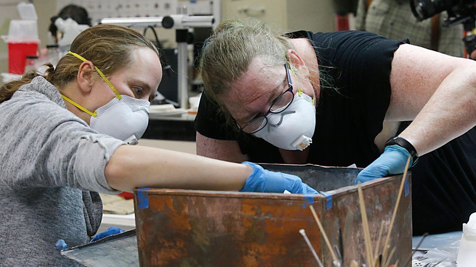 Die Restauratorinnen Sue Donovan (l.) und Kate Ridgeway untersuchen die Zeitkapsel, die im Sockel der umstrittenen Statue des Südstaaten-Generals Robert E. Lee im US-Bundesstaat Virgina gefunden worden war