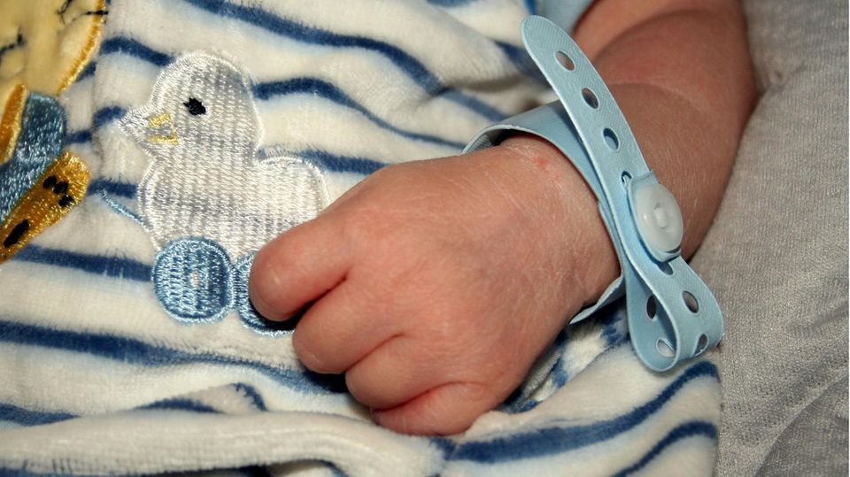 Ein Neugeborenes mit Namensband ums Handgelenk. Als Vorname waren 2021 Emilia und Matteo besonders beliebt.