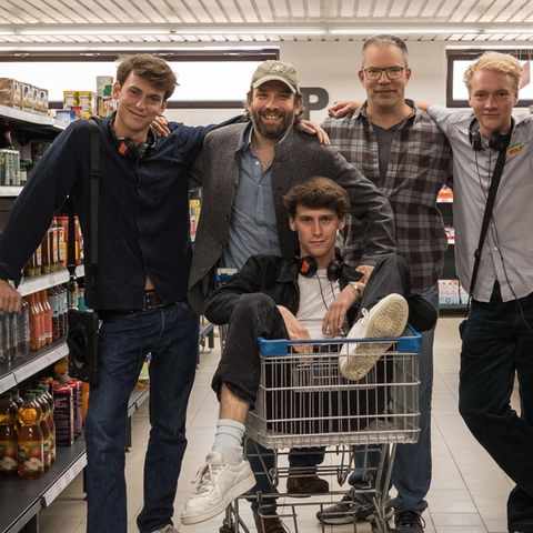 Die Produzenten und das Kreativteam von "Die Discounter" stehen am Set inmitten von Supermarkt-Regalen