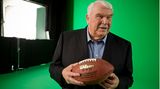 John Madden hält einen Football in der Hand