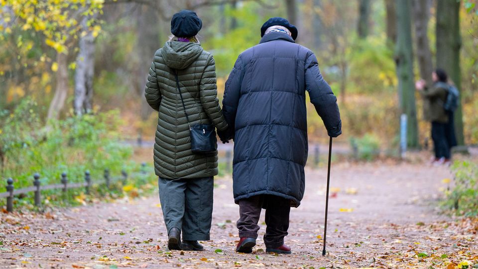 Rente in Deutschland: Ein älteres Paar spaziert durch einen Park