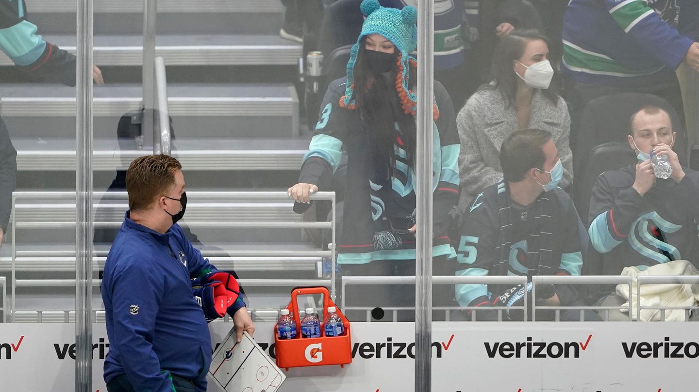 Brian Hamilton, Betreuer der Vancouver Canucks (links) und Eishockeyfan Nadia Popovici (mit Mütze) bei ihrem Wiedersehen am Neujahrstag