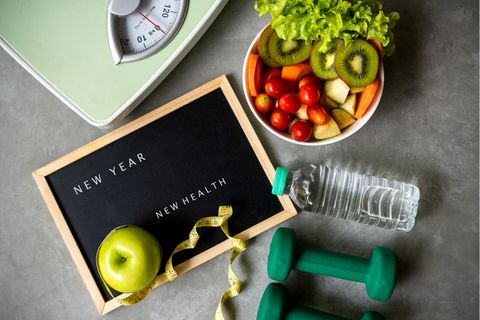 Eine Waage, Obst und Gemüse, Hanteln und ein Maßband.