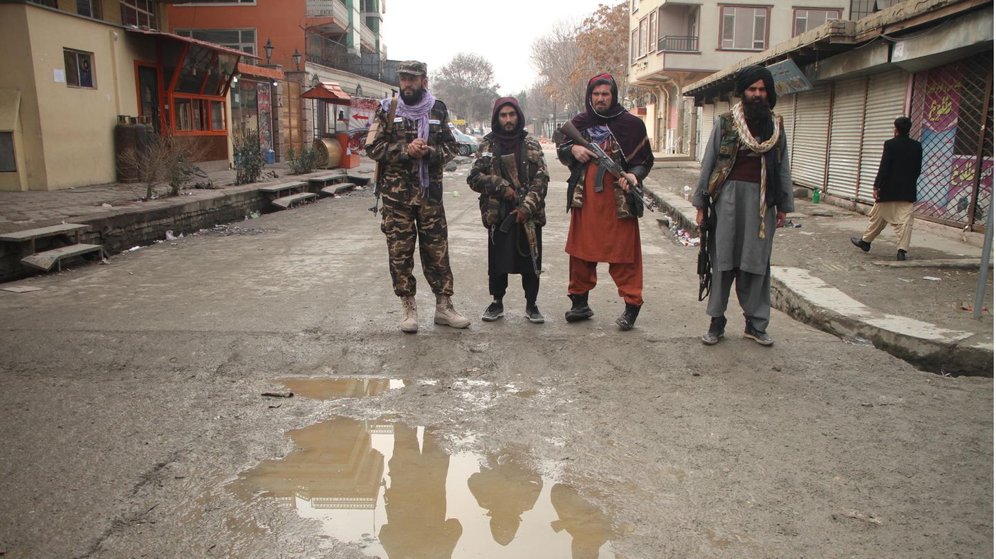 Bewaffnete Mitglieder der Taliban in Afghanistan stehen auf einer Straße Wache