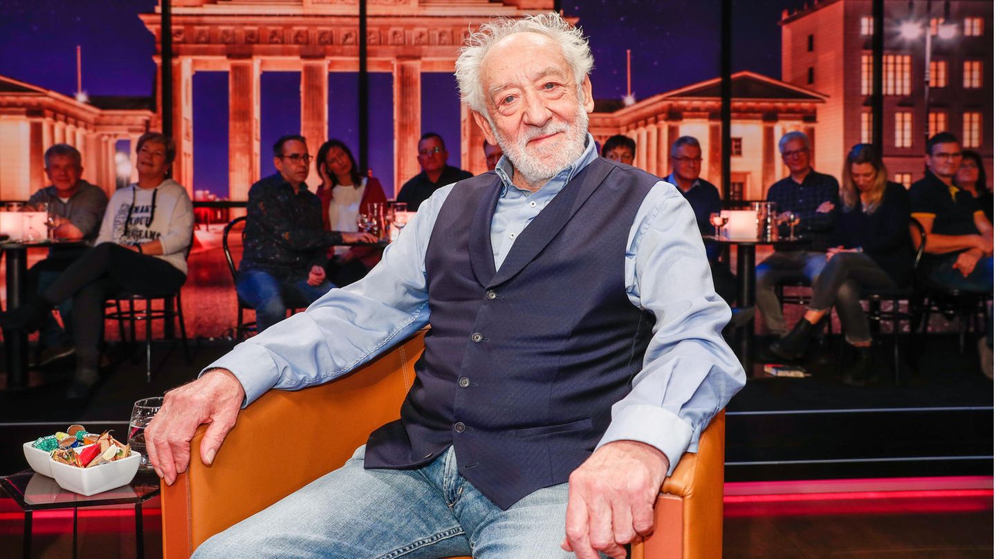 Dieter Hallervorden sitz in einem TV-Studio vor einem Foto des Brandenburger Tors