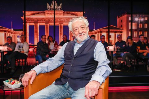 Dieter Hallervorden sitz in einem TV-Studio vor einem Foto des Brandenburger Tors