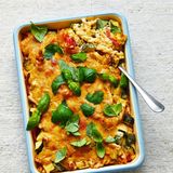 Cheezy Ofennudeln mit Gemüse      Zutaten: 2 Zucchini, 400 g Tomaten, 1 Zwiebel, 2 Zweige Rosmarin, 300 g Gemelli-Pasta (ersatzweise Fusilli), 500 ml Gemüsebrühe, 800 ml Cashewsauce, Salz, etwas Basilikum   Außerdem: Auflaufform (22 × 22 cm)      Zubereitung:  1.Den Backofen auf 180° vorheizen. Das Gemüse waschen und abtropfen lassen. Die Zucchini putzen, längs vierteln (eventuell sehr mehliges Kerngehäuse entfernen) und die Viertel quer in ca. 2 cm große Stücke schneiden. Die Tomaten vierteln, größere Exemplare sechsteln und das Kerngehäuse sowie die Stielansätze entfernen. Die Zwiebel schälen und in grobe Würfel schneiden. Den Rosmarin waschen und trocken schütteln. Die Rosmarinnadeln von den Stielen zupfen und fein hacken.  2. Die Nudeln in die Auflaufform geben. Das Gemüse darüber verteilen und etwas unter die Nudeln heben – der Großteil der Nudeln sollte sich aber auf dem Boden der Form befinden. Gemüsebrühe, Rosmarin und die Cashewsauce zu einer glatten Flüssigkeit verquirlen, diese mit Salz abschmecken und in die Form gießen.  3. Die Nudeln im Backofen (2. Schiene von unten) 45 Min. backen. Herausnehmen und 2–3 Min. setzen lassen. Inzwischen den Basilikum waschen, trocken schütteln und holzige Stiele entfernen. Zum Servieren den Basilikum grob über den Auflauf zupfen.