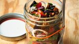 Auberginensalat mit Currykernen      Zutaten:  Für den Salat: 1 Aubergine, Salz, 1 kleine rote Zwiebel, 300 g Kirschtomaten, 6 Zweige Minze, ½ Bund Petersilie, neutrales Pflanzenöl, 2 EL natives Leinöl (ersatzweise Olivenöl), 4 EL Weißwein- oder Apfelessig (naturtrüb), 1 TL mittelscharfer Senf Für die Currykerne: 2 EL Sonnenblumenkerne, 2 EL Kürbiskerne, 1 EL Zucker, 1 Prise Salz, ½ TL scharfes Currypulver      Zubereitung:  1. Die Aubergine waschen, putzen und in ca. 2 cm dicke Scheiben schneiden. Die Scheiben auf einen Teller legen, mit 1 TL Salz bestreuen und 30 Min. ziehen lassen.  2. In der Zwischenzeit die Zwiebel schälen und in sehr dünne Ringe schneiden. Die Tomaten waschen, abtropfen lassen und in Scheiben schneiden, die Stielansätze dabei entfernen. Die Kräuter waschen, trocken schütteln und hacken. Zwiebeln, Kräuter und Tomaten in eine Schüssel geben und beiseitestellen.  3. Die gesalzene Aubergine mit Küchenpapier trocken tupfen und die Scheiben in ca. 1 cm breite Streifen schneiden. Das Öl in einer Pfanne erhitzen und die Auberginenstreifen von allen Seiten scharf darin anbraten, bis sie goldbraun und weich sind. Die Auberginenstreifen lauwarm abkühlen lassen, dann mit den Tomaten, Zwiebeln und Kräutern mischen.  4. Leinöl, Essig und Senf zu einer sämigen Sauce mixen und das Dressing kräftig mit Salz abschmecken.  5. Für die Currykerne die Sonnenblumen- und Kürbiskerne in einer kleinen Pfanne ohne Öl auf mittlerer Temperatur anrösten, bis sie gut duften. Dann Zucker, 1 Prise Salz und Currypulver mischen und zu den Kernen geben. Alles unter Rühren 1–2 Min. vorsichtig erhitzen, bis der Zucker geschmolzen ist. 1 EL Wasser dazugeben und unter Rühren verkochen lassen, die Pfanne vom Herd ziehen und die Kerne abkühlen lassen. Den Salat in eine Box zum Mitnehmen verpacken. Dressing und Kerne separat einpacken und erst kurz vor dem Essen zum Salat geben.
