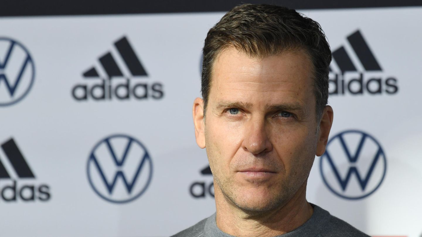 Oliver Bierhoff vor einer Werbetafel, ein Schatten bedeckt die eine Hälfte seines Gesichts