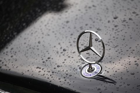 Ein Mercedes-Stern auf der Kühlerhaube eines Mercedes mit Regentropfen