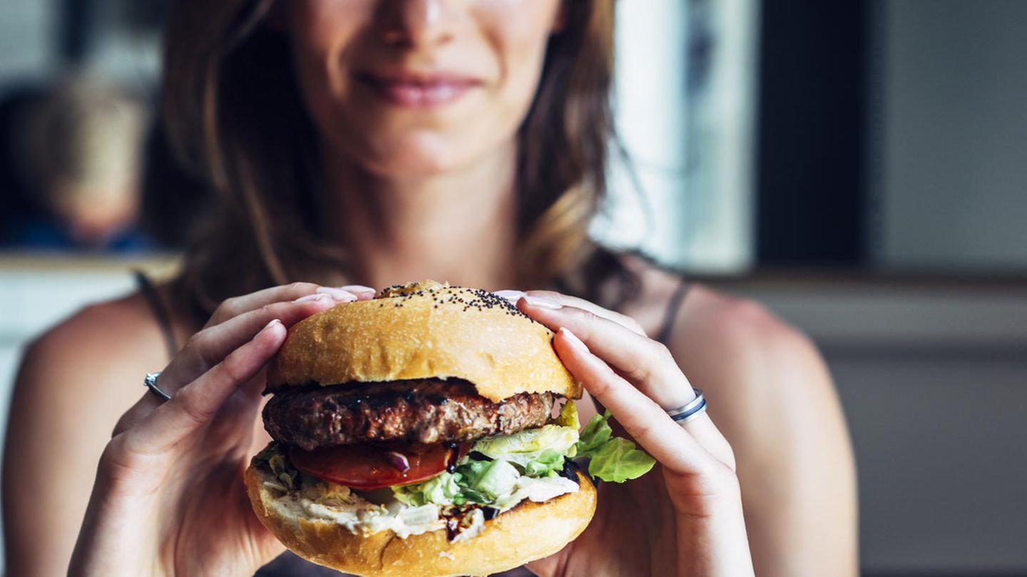 Abnehmen als Neujahrsvorsatz: Eine Frau hält einen Burger