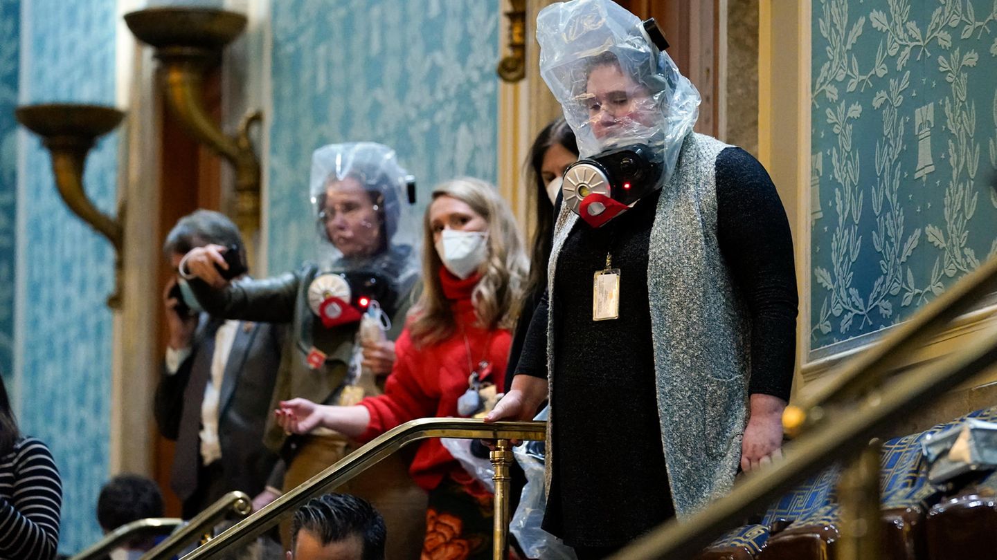 Schutzhauben sollen die Eingeschlossenen vor Tränengas schützen, das vor dem Saal versprüht wurde