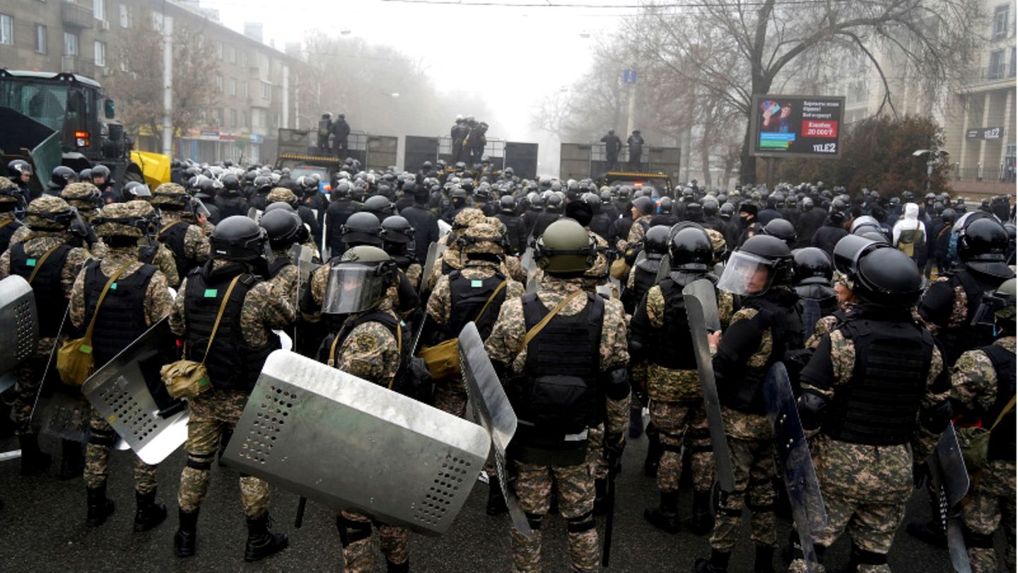 Kasachstan, Almaty: Bereitschaftspolizisten blockieren eine Straße, um Demonstranten aufzuhalten