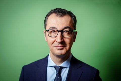 Cem Özdemir im Portrait vor einem grünen Hintergrund