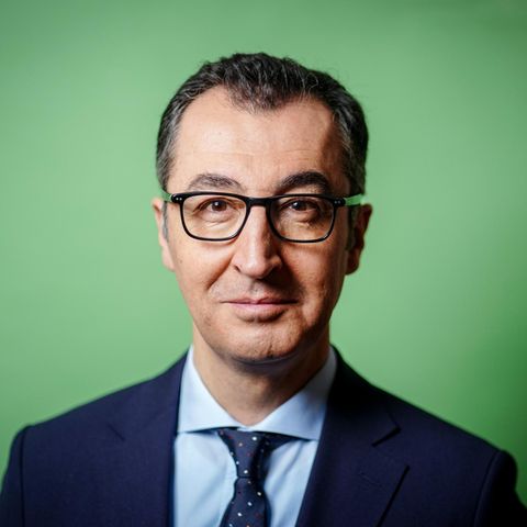 Cem Özdemir im Portrait vor einem grünen Hintergrund