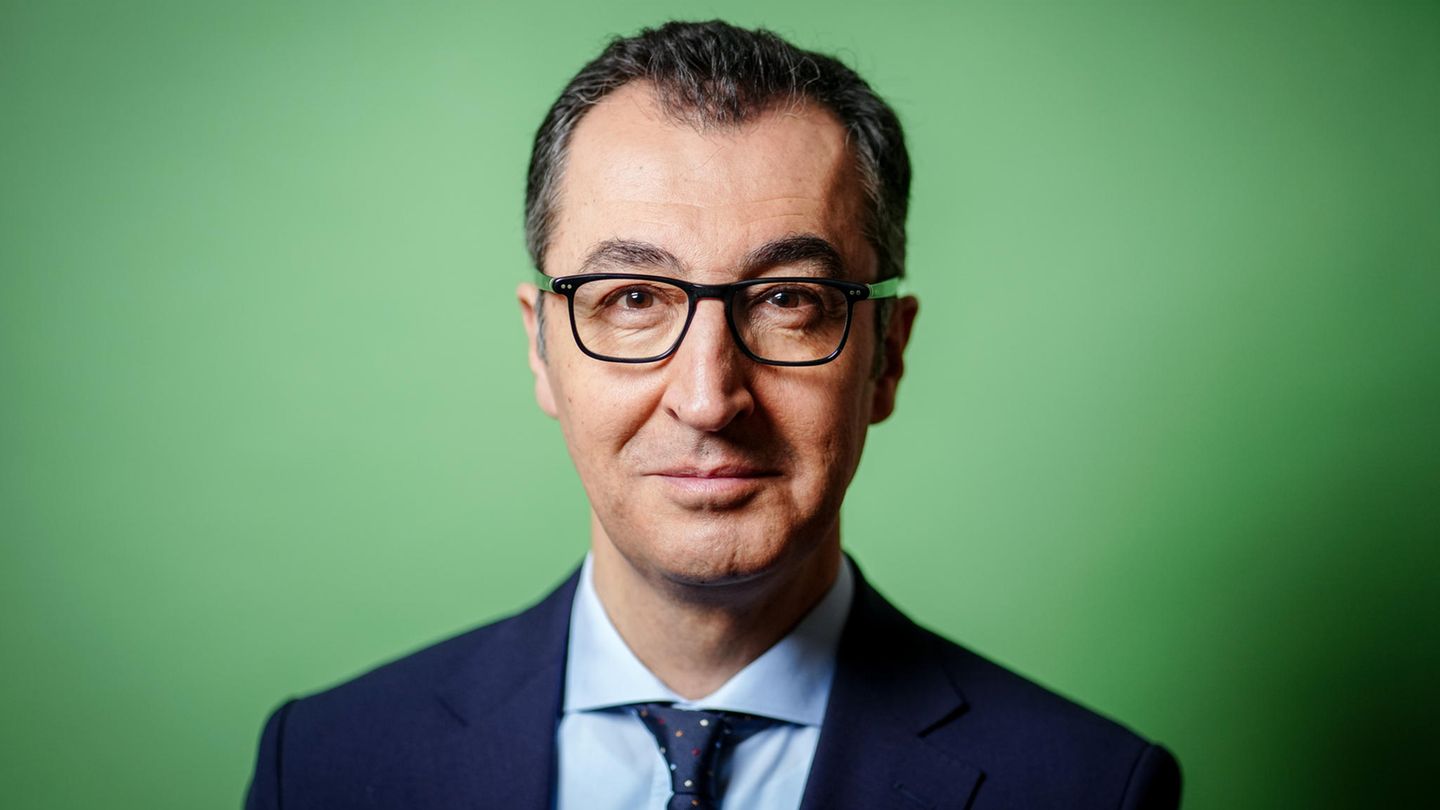 Cem Özdemir im Portrait vor einem grünen Hintergrund