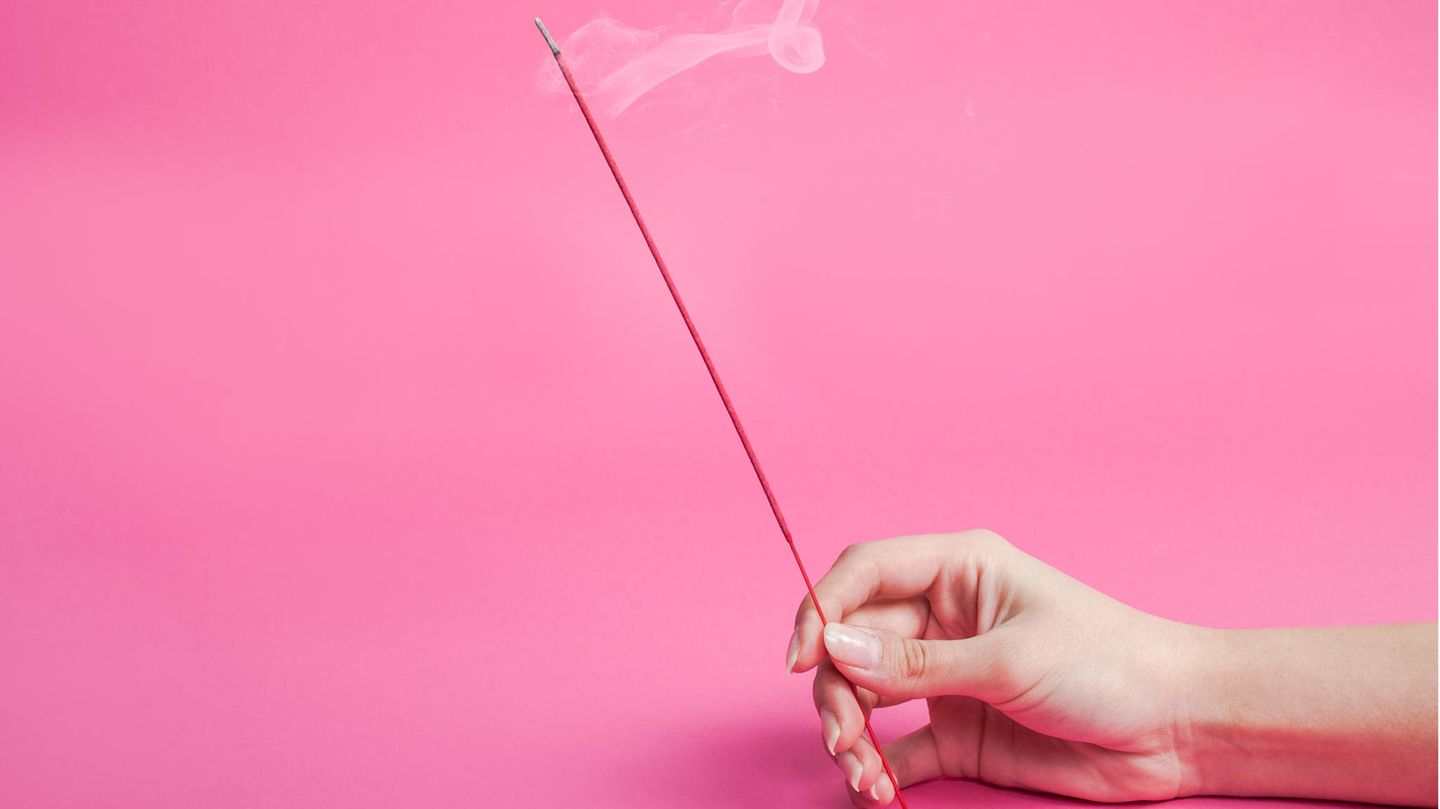 Person holding incense sticks