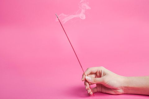 Person hält Räucherstäbchen in der Hand
