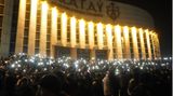 Demonstranten leuchten mit ihren Smartphones, während sie sich in der Innenstadt versammeln. 
