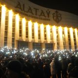 Demonstranten leuchten mit ihren Smartphones, während sie sich in der Innenstadt versammeln. 