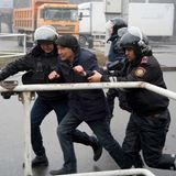 Polizeibeamte halten einen Demonstranten fest.