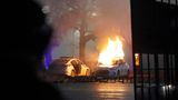 Ein Polizeiauto steht in Flammen. 
