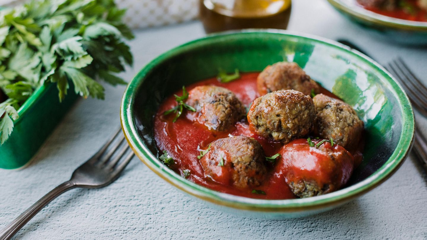 Vegane Frikadellen in einer grünen Schüssel mit Tomatensoße