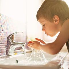 Kleine Junge trinkt Leitungswasser