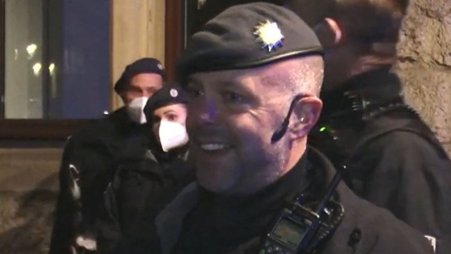 Ein Polizist in Münster diskutiert mit einem Corona-Spaziergänger