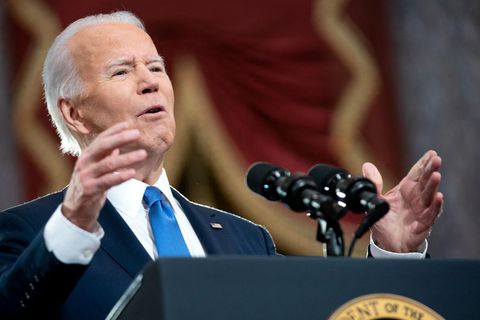 Ein weißer Mann mit weißem, zurückgekämmtem Haar gestikuliert hinter einem Rednerpult mit dem Wappen des US-Präsidenten