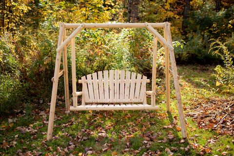 Hollywoodschaukel wetterfest machen: Frau mit warmen Socken und Tasse auf einer Hollywoodschaukel