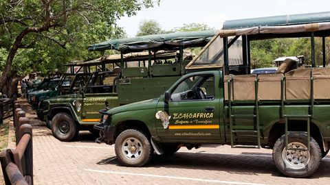 Safari-Fahrzeuge auf einem Parkplatz im Camp Skukuza, Krüger Nationalpark, Südafrika.