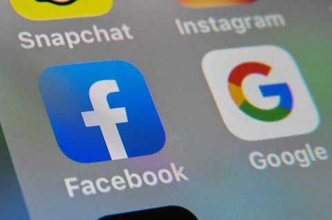 Die Logos von Facebook und Google sind auf dem Bildschirm eines Smartphones zu sehen