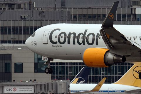 Ein weißes Passagierflugzeug mit dunkelblauem "Condor"-Scchriftzug und orange-gelben Triebwerken landet auf einem Flughafen